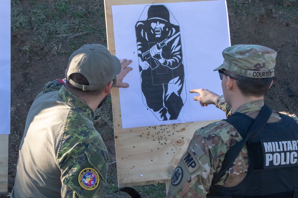 Spc. James Courser and a Canadian Armed Forces military policeman sight their weapons at targets during joint training in Mihail Kogălniceanu, Romania, December 2019